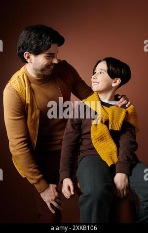 Un père et son fils partagent un moment tendre, leurs yeux enfermés dans un regard aimant. Banque D'Images