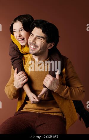 Un père et son fils partagent une étreinte chaleureuse, tous deux souriant brillamment. Banque D'Images