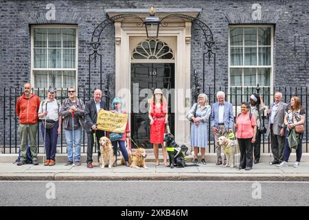 Londres, 22 juillet 2024. La National Federation of the Blind of the UK (NFBUK) remet une pétition au 10 Downing Street appelant à un arrêt temporaire de tous les arrêts de bus flottants prévus dans les nouvelles voies cyclables à travers le Royaume-Uni, car il s'agit d'une préoccupation importante pour la sécurité des personnes aveugles et autres. La pétition est organisée par Sarah Gayton (aux cheveux bleus), soutenue par le président de l'Association européenne des chiens aveugles, David Adams avec le chien Jimbo et le député de Libdem Steve Darling avec le chien guide Jennie, Sarah Leadbetter avec Nellie, et d'autres. Crédit : Imageplotter/Alamy Live News Banque D'Images