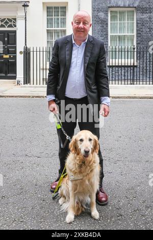 Londres, 22 juillet 2024. Steve Darling, député, avec son chien-guide Jennie. La National Federation of the Blind of the UK (NFBUK) remet une pétition au 10 Downing Street appelant à un arrêt temporaire de tous les arrêts de bus flottants prévus dans les nouvelles voies cyclables à travers le Royaume-Uni, car il s'agit d'une préoccupation importante pour la sécurité des personnes aveugles et autres. La pétition est organisée par Sarah Gayton (aux cheveux bleus), soutenue par le président de l'Association européenne des chiens aveugles, David Adams avec le chien Jimbo et le député de Libdem Steve Darling avec le chien guide Jennie, Sarah Leadbetter avec Nellie, et d'autres. Banque D'Images