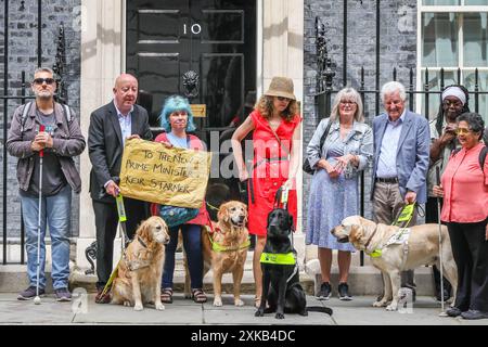 Londres, 22 juillet 2024. La National Federation of the Blind of the UK (NFBUK) remet une pétition au 10 Downing Street appelant à un arrêt temporaire de tous les arrêts de bus flottants prévus dans les nouvelles voies cyclables à travers le Royaume-Uni, car il s'agit d'une préoccupation importante pour la sécurité des personnes aveugles et autres. La pétition est organisée par Sarah Gayton (aux cheveux bleus), soutenue par le président de l'Association européenne des chiens aveugles, David Adams avec le chien Jimbo et le député de Libdem Steve Darling avec le chien guide Jennie, Sarah Leadbetter avec Nellie, et d'autres. Crédit : Imageplotter/Alamy Live News Banque D'Images