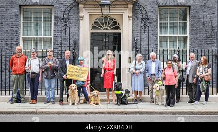 Londres, 22 juillet 2024. La National Federation of the Blind of the UK (NFBUK) remet une pétition au 10 Downing Street appelant à un arrêt temporaire de tous les arrêts de bus flottants prévus dans les nouvelles voies cyclables à travers le Royaume-Uni, car il s'agit d'une préoccupation importante pour la sécurité des personnes aveugles et autres. La pétition est organisée par Sarah Gayton (aux cheveux bleus), soutenue par le président de l'Association européenne des chiens aveugles, David Adams avec le chien Jimbo et le député de Libdem Steve Darling avec le chien guide Jennie, Sarah Leadbetter avec Nellie, et d'autres. Crédit : Imageplotter/Alamy Live News Banque D'Images