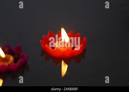 Bougies de Krathong avec des flammes flottant sur l'eau, Un rituel bouddhiste qui est censé enlever les mauvaises choses de la vie quand les bougies flottent. Banque D'Images