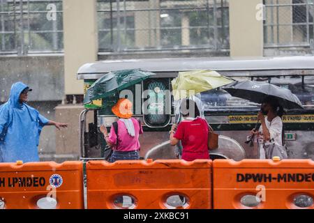 Quezon City, Philippines. 22 juillet 2024. Les gens utilisent des parapluies pour éviter les fortes pluies apportées par le typhon Gaemi à Quezon City, Philippines, le 22 juillet 2024. Crédit : Rouelle Umali/Xinhua/Alamy Live News Banque D'Images