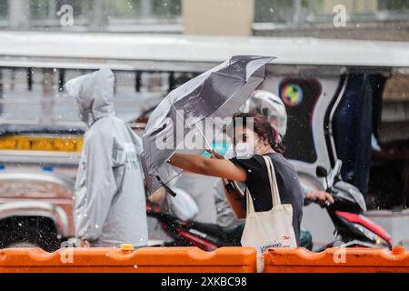 Quezon City, Philippines. 22 juillet 2024. Une femme utilise un parapluie pour éviter les fortes pluies apportées par le typhon Gaemi à Quezon City, Philippines, le 22 juillet 2024. Crédit : Rouelle Umali/Xinhua/Alamy Live News Banque D'Images