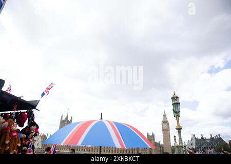 Backdrop par Elizabeth Tower qui abrite Big Ben, un parapluie sur le thème de l'union Jack et des drapeaux de l'Union sont vus à l'extérieur d'un stand de souvenirs à Londres. Banque D'Images