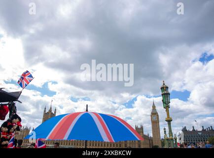 Backdrop par Elizabeth Tower qui abrite Big Ben, un parapluie sur le thème de l'union Jack et des drapeaux de l'Union sont vus à l'extérieur d'un stand de souvenirs à Londres. Banque D'Images