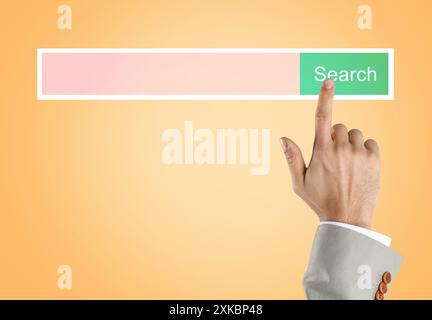 Homme utilisant la barre de recherche sur l'écran virtuel sur fond orange, gros plan Banque D'Images