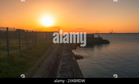 Coucher de soleil d'été à l'arrière du Dún Laoghaire West Pier Banque D'Images