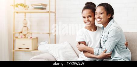 Deux belles soeurs afro-américain hugging at home Banque D'Images