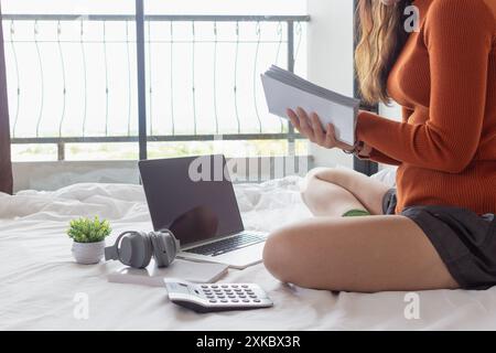 La fille lisait attentivement le manuel dans sa main pour comprendre et apprendre les leçons du manuel qu'elle a reçu de l'enseignant. concept d'apprentissage et de reviewin Banque D'Images