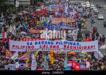 Quezon City, Philippines. 22 juillet 2024. Les manifestants défilent avec des banderoles exprimant leur opinion sur Commonwealth Avenue pendant la manifestation. Les militants et les défenseurs des droits de l'homme se rassemblent dans les rues pour exprimer leurs points de vue et leur désapprobation du discours de la troisième station de la nation du Président Marcos Jr. Le président prévoyait discuter de divers sujets, dont l'inflation, le chômage et, très probablement, la crise actuelle dans la mer des Philippines occidentale. Crédit : SOPA images Limited/Alamy Live News Banque D'Images