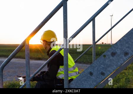 Ingénieur avec tablette numérique contrôle les éoliennes. Banque D'Images