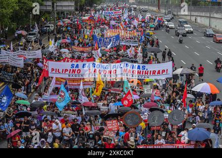 Quezon City, Philippines. 22 juillet 2024. Les manifestants défilent avec des banderoles exprimant leur opinion sur Commonwealth Avenue pendant la manifestation. Les militants et les défenseurs des droits de l'homme se rassemblent dans les rues pour exprimer leurs points de vue et leur désapprobation du discours de la troisième station de la nation du Président Marcos Jr. Le président prévoyait discuter de divers sujets, dont l'inflation, le chômage et, très probablement, la crise actuelle dans la mer des Philippines occidentale. (Photo de Ryan Eduard Benaid/SOPA images/Sipa USA) crédit : Sipa USA/Alamy Live News Banque D'Images