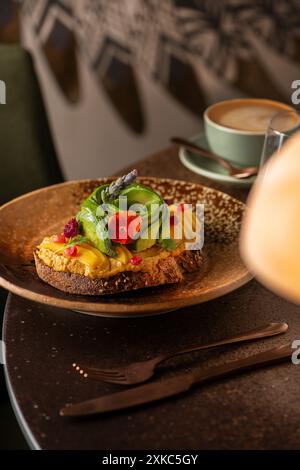 Toast à l'avocat et au houmous sur une table de restaurant. Heure du brunch. Pain au levain. Banque D'Images