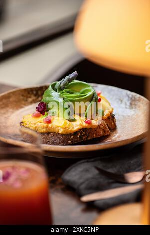 Toast à l'avocat et au houmous sur une table de restaurant. Heure du brunch. Pain au levain. Banque D'Images