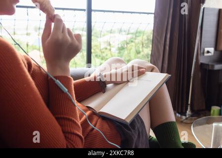 La fille lisait attentivement le manuel dans sa main pour comprendre et apprendre les leçons du manuel qu'elle a reçu de l'enseignant. concept d'apprentissage et de reviewin Banque D'Images