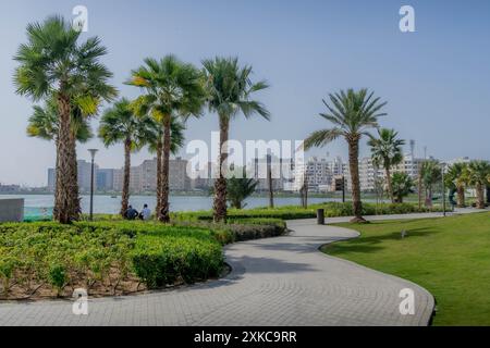 Les palmiers et la promenade (Corniche) à Jeddah Waterfront, Arabie Saoudite, pendant la chaude journée d'été au moyen-Orient. Banque D'Images