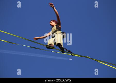 Cracovie. Cracovie. Pologne. Jeune femme aérographe exécutant un spectacle de corde raide au-dessus de l'Old Market place. Avion avec des traînées vues en arrière-plan. Rue Banque D'Images