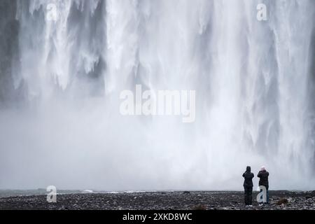 Chutes de Skogafoss est de 60 mètres de haut. L'eau vient du glacier - Tourist Picturing | chute d'eau de Skogafoss est heute de 60 mètres et l'eau vient Banque D'Images