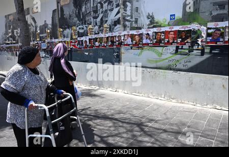 Jérusalem, Israël. 22 juillet 2024. Les Israéliens regardent les affiches des otages israéliens retenus en captivité par le Hamas à Gaza dans une rue de Jérusalem le lundi 22 juillet 2024. Le premier ministre israélien Benjamin Netanyahu doit rencontrer le président américain Joe Biden et s’adresser à une session conjointe du Congrès à Washington, DC cette semaine, tandis qu’une majorité de l’opinion publique israélienne affirme qu’il a saboté un accord d’otages pour sa survie politique. Photo de Debbie Hill/ crédit : UPI/Alamy Live News Banque D'Images