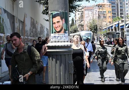 Jérusalem, Israël. 22 juillet 2024. Les Israéliens passent devant une affiche représentant un soldat israélien tué à Gaza appelant à la victoire complète sur le Hamas dans une rue de Jérusalem le lundi 22 juillet 2024. Le premier ministre israélien Benjamin Netanyahu doit rencontrer le président américain Joe Biden et s’adresser à une session conjointe du Congrès à Washington, DC cette semaine, tandis qu’une majorité de l’opinion publique israélienne affirme qu’il a saboté un accord d’otages pour sa survie politique. Photo de Debbie Hill/ crédit : UPI/Alamy Live News Banque D'Images