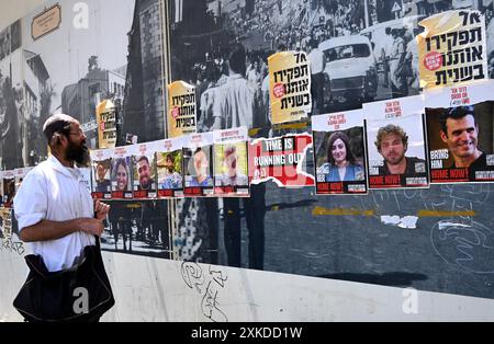 Jérusalem, Israël. 22 juillet 2024. Un homme ultra-orthodoxe regarde des affiches d’otages israéliens retenus captifs par le Hamas à Gaza dans une rue de Jérusalem le lundi 22 juillet 2024. Le premier ministre israélien Benjamin Netanyahu doit rencontrer le président américain Joe Biden et s’adresser à une session conjointe du Congrès à Washington, DC cette semaine, tandis qu’une majorité de l’opinion publique israélienne affirme qu’il a saboté un accord d’otages pour sa survie politique. Photo de Debbie Hill/ crédit : UPI/Alamy Live News Banque D'Images