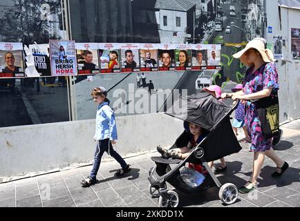 Jérusalem, Israël. 22 juillet 2024. Les Israéliens passent devant des affiches d’otages israéliens retenus en captivité par le Hamas à Gaza dans une rue de Jérusalem le lundi 22 juillet 2024. Le premier ministre israélien Benjamin Netanyahu doit rencontrer le président américain Joe Biden et s’adresser à une session conjointe du Congrès à Washington, DC cette semaine, tandis qu’une majorité de l’opinion publique israélienne affirme qu’il a saboté un accord d’otages pour sa survie politique. Photo de Debbie Hill/ crédit : UPI/Alamy Live News Banque D'Images