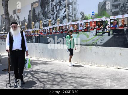 Jérusalem, Israël. 22 juillet 2024. Israéliens ont passé des affiches d’otages israéliens retenus captifs par le Hamas à Gaza dans une rue de Jérusalem le lundi 22 juillet 2024. Le premier ministre israélien Benjamin Netanyahu doit rencontrer le président américain Joe Biden et s’adresser à une session conjointe du Congrès à Washington, DC cette semaine, tandis qu’une majorité de l’opinion publique israélienne affirme qu’il a saboté un accord d’otages pour sa survie politique. Photo de Debbie Hill/ crédit : UPI/Alamy Live News Banque D'Images