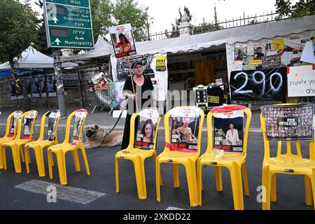 Jérusalem, Israël. 22 juillet 2024. Une femme tient une pancarte derrière des chaises vides avec des photos d’otages israéliens retenus captifs par le Hamas à Gaza dans une rue de Jérusalem le lundi 22 juillet 2024. Le premier ministre israélien Benjamin Netanyahu doit rencontrer le président américain Joe Biden et s’adresser à une session conjointe du Congrès à Washington, DC cette semaine, tandis qu’une majorité de l’opinion publique israélienne affirme qu’il a saboté un accord d’otages pour sa survie politique. Photo de Debbie Hill/ crédit : UPI/Alamy Live News Banque D'Images