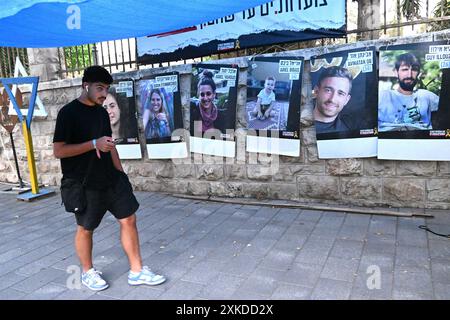 Jérusalem, Israël. 22 juillet 2024. Un homme passe devant des affiches d’otages israéliens retenus captifs par le Hamas à Gaza dans une rue de Jérusalem le lundi 22 juillet 2024. Le premier ministre israélien Benjamin Netanyahu doit rencontrer le président américain Joe Biden et s’adresser à une session conjointe du Congrès à Washington, DC cette semaine, tandis qu’une majorité de l’opinion publique israélienne affirme qu’il a saboté un accord d’otages pour sa survie politique. Photo de Debbie Hill/ crédit : UPI/Alamy Live News Banque D'Images