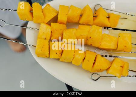 morceaux d'ananas grillés sur des brochettes en métal Banque D'Images