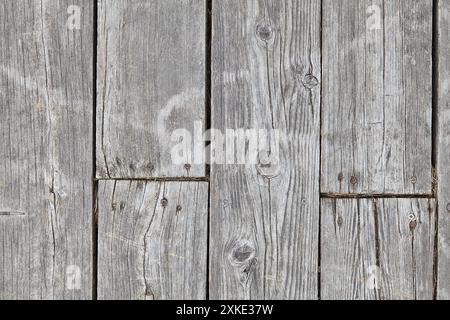 Fond texturé de planches de bois altérées avec des fissures, des nœuds et des vis Banque D'Images