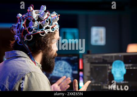 Développeur de logiciels utilisant un casque EEG traduisant des pensées en commandes PC à l'aide de signaux d'onde cérébrale. IT professionnel contrôlant les fonctions informatiques en utilisant l'esprit, aidé par la technologie, gros plan Banque D'Images