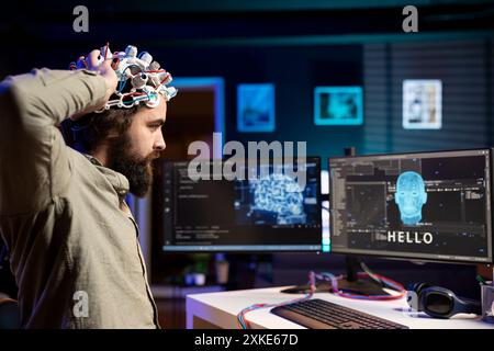 Homme plaçant un casque EEG sur la tête pour communiquer avec l'entité d'intelligence artificielle avec le corps anthropomorphe. Programmeur logiciel utilisant un équipement de haute technologie pour parler avec un robot ai sous forme humanoïde Banque D'Images