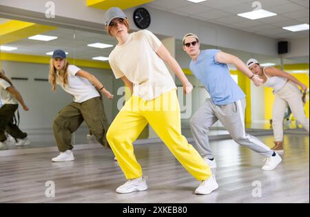 Garçons et filles dansant la chorégraphie de groupe synchrone dans la salle de danse Banque D'Images