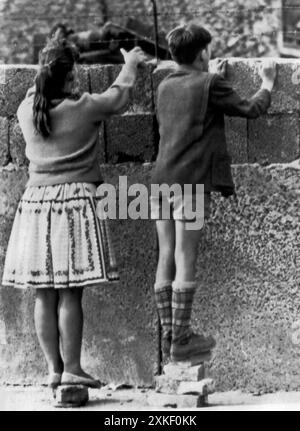 Berlin, Allemagne de l'Ouest 29 août 1961 deux enfants ouest-allemands regardent au-dessus du mur nouvellement construit dans Berlin est. Banque D'Images