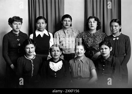 Lawrence, Kansas c 1933 étudiants amérindiens à l'Institut Haskell. Rangée supérieure, G-d : Chippewa, Sioux, Kikapoo, Blackfoot, Cherokee. Bas, G-d : Seneca, Cheyenne, Chippewa, Potawatomie. Ils ont conçu les tapis en caoutchouc pour être utilisés dans les entrées du nouveau département intérieur Bulding. Banque D'Images