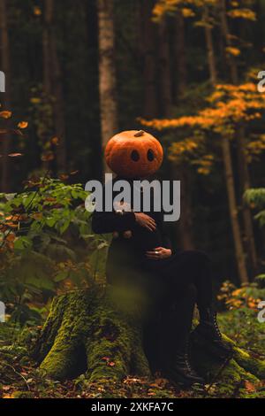 femme effrayante avec tête de citrouille dans la forêt avec des vacances d'halloween jouet Banque D'Images