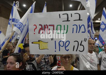 LOD, ISRAËL - 21 JUILLET : un manifestant brandit une pancarte qui dit "Bibi, et la Haye? C'est là » (en référence à la Cour pénale internationale de la Haye) alors que des manifestants anti-gouvernementaux et pro-accords d'otages manifestent contre la visite prochaine du premier ministre Benjamin Netanyahu aux États-Unis à l'aéroport Ben Gourion près de tel Aviv le 21 juillet 2024 à Lod, Israël. Les manifestants exhortent Netanyahu à s’abstenir de se rendre à Washington jusqu’à ce qu’un accord soit conclu avec le Hamas pour faciliter le retour des otages israéliens détenus à Gaza. Banque D'Images