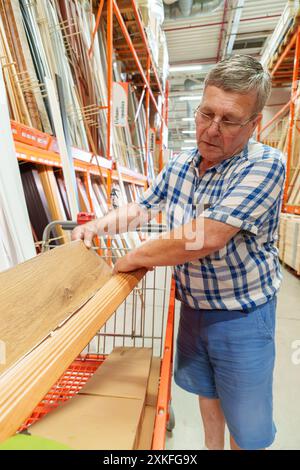 Título : homme hispanique à la retraite dans ses 70 ans qui choisit du bois à acheter au magasin pour faire des rénovations à sa maison Banque D'Images