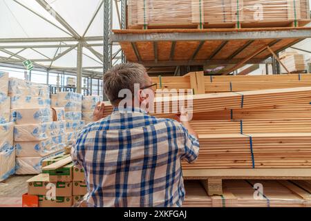 Título : homme hispanique à la retraite dans ses 70 ans qui choisit du bois à acheter au magasin pour faire des rénovations à sa maison Banque D'Images