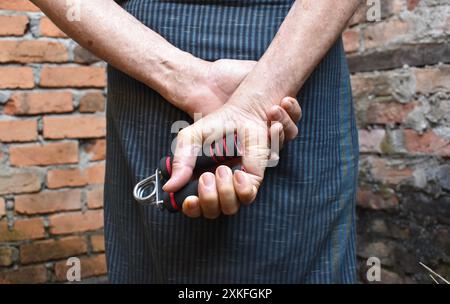 Asie du Sud-est, Myanmar vieil homme saisissant main exercice pince. Banque D'Images