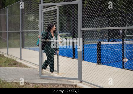 Femme entrant sur le court de tennis de padel en costume vert Banque D'Images