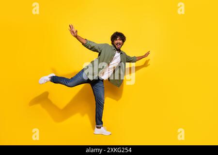 Portrait photo de jeune mec mexicain drôle dans la chemise kaki sentant la liberté ailes volantes isolées sur fond de couleur jaune Banque D'Images