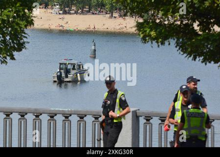 Kiev, Ukraine. 21 juillet 2024. Policiers et sauveteurs vus lors d'une opération de recherche et de sauvetage pour un homme tombé dans la rivière Dnipro après une rupture de câble sur un téléphérique à Kiev. Les sauveteurs recherchent un homme qui est tombé dans la rivière Dnipro en raison d'une rupture dans le câble de l'attraction, a rapporté l'administration d'État de la ville de Kiev. Plongeurs, bateaux et équipements spéciaux sont impliqués dans l'opération de recherche. Crédit : SOPA images Limited/Alamy Live News Banque D'Images