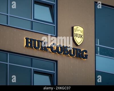 Logo HUK-Coburg signe de la grande compagnie d'assurance allemande. Logotype illuminé sur un mur d'immeuble de bureaux. Fournisseur d'assurance responsabilité civile. Banque D'Images