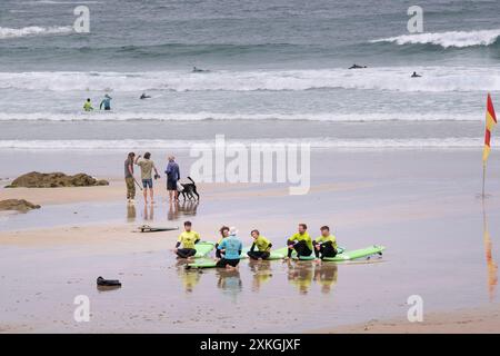 Une leçon de surf sur GT Great Western Beach. Un groupe de novices de surf avec leur instructeur de surf de l'Escape Surf School à Newquay en Cornouailles Banque D'Images