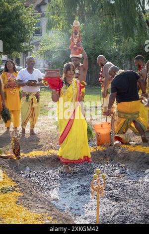 Un fidèle hindou pieux marche pieds nus sur des charbons brûlants au Thimithi Fire Walking Festival au Arya Spiritual Grounds à Jamaica, Queens, NY Banque D'Images