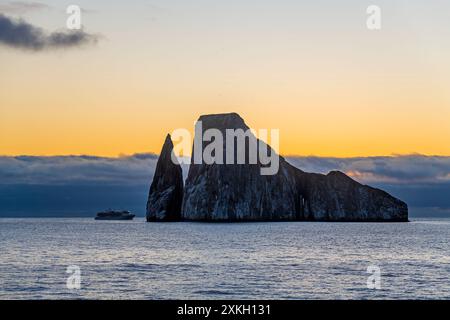 Bateau de croisière par Kicker Rock formation au coucher du soleil, île de San Cristobal, parc national des Galapagos, Équateur. Banque D'Images